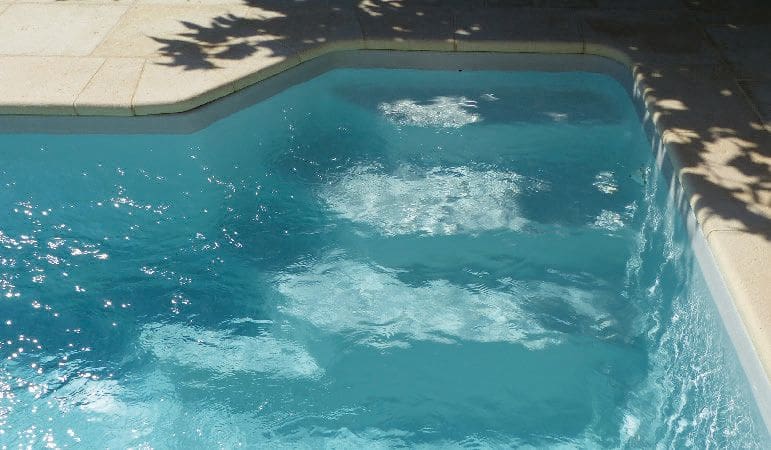 Venus fibreglass swimming pool installed within a landscaped garden